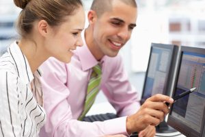 Businessman and woman working on computers